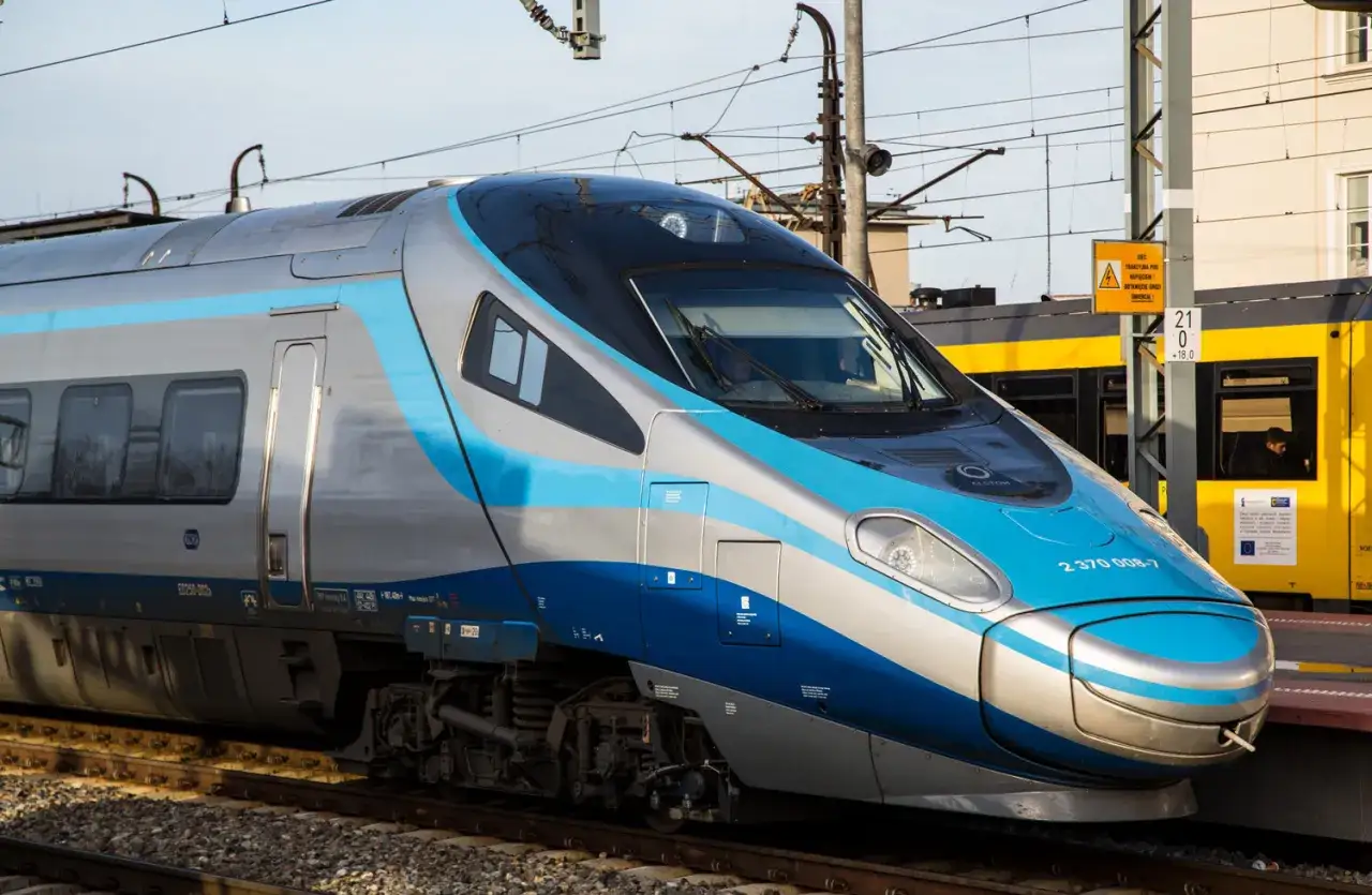 Srebrno-niebieskie Pendolino gotowe do podróży do Szczecina. Pociąg stoi na peronie obok żółtego składu.