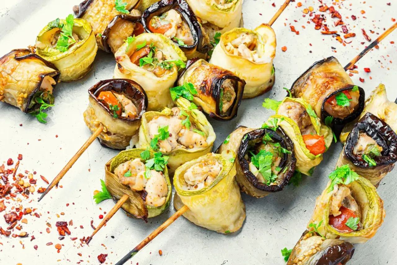 Roladki z bakłażana i cukinii z kurczakiem, posypane ziołami. Idealne przystawki na grilla.