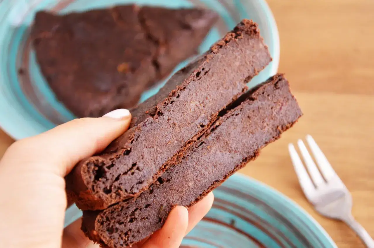 Dwa kawałki wilgotnego brownie z cukinii, idealne na codziennie fit przekąskę.