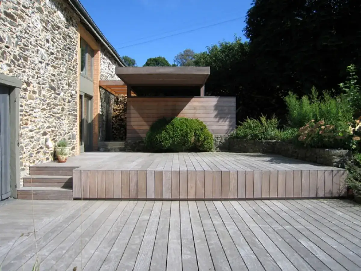 Nowoczesny taras z deski kompozytowej, idealne miejsce na relaks w otoczeniu zieleni.
