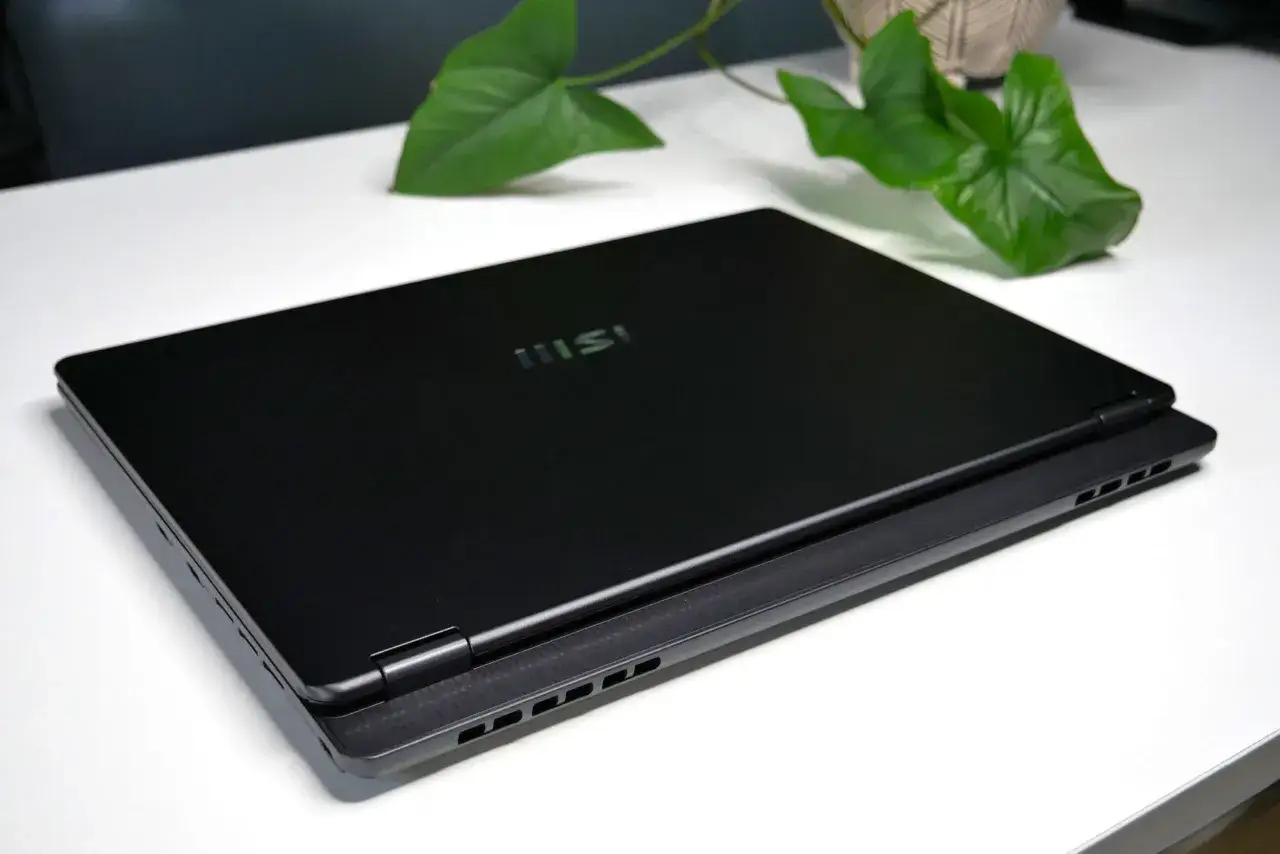 Elegancki, czarny laptop MSI na białym biurku. Zastanawiasz się, ile kosztują laptopy tej klasy?