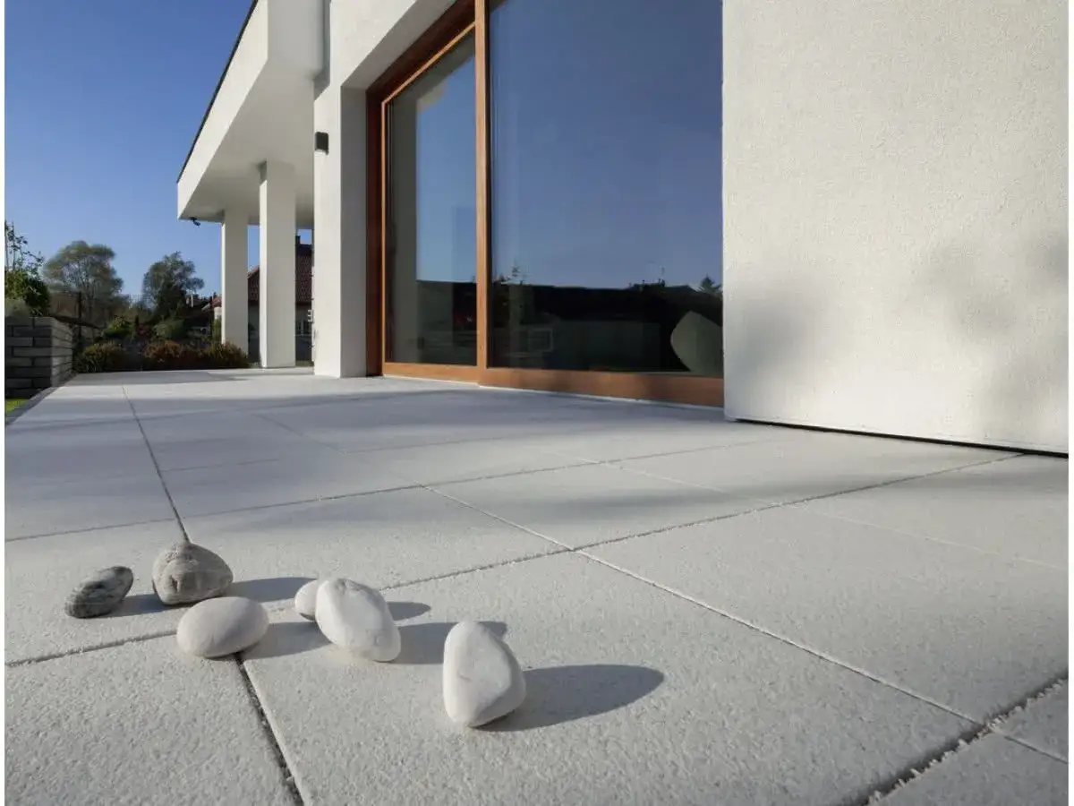 Kamienie na jasnej, betonowej podłodze balkonu. Idealne co na balkon na podłogę, by stworzyć naturalny klimat.
