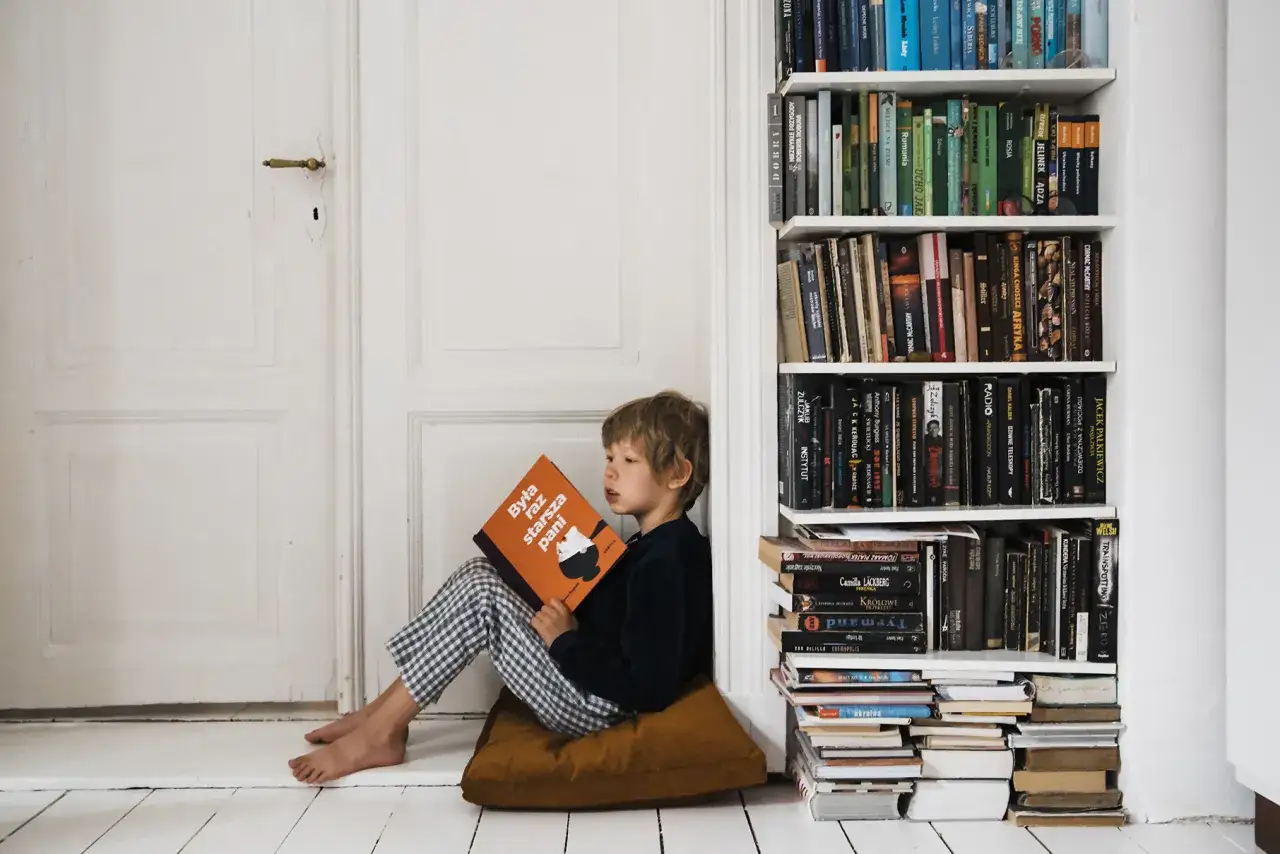 Dziecko zniechęcone do nauki, siedzące nad książkami