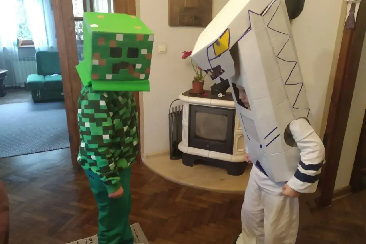 Dwa chłopcy w strojach karnawałowych DIY: jeden jako Creeper z Minecrafta, drugi w białym stroju z niebieskimi detalami.