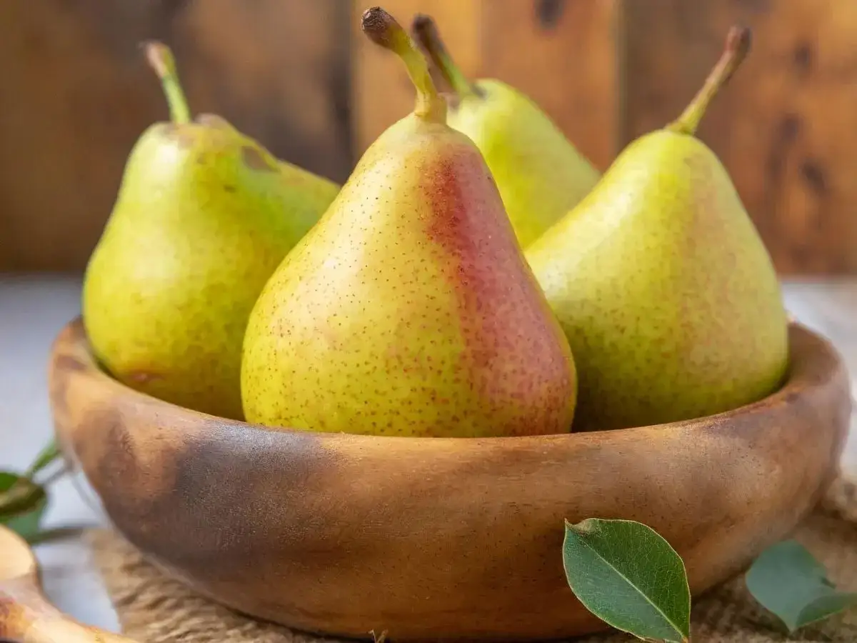 Gruszki w drewnianej misie, idealne na jesienne przetwory. Zastanawiasz się, co zrobić z gruszek? Kompot, dżem, a może ciasto?