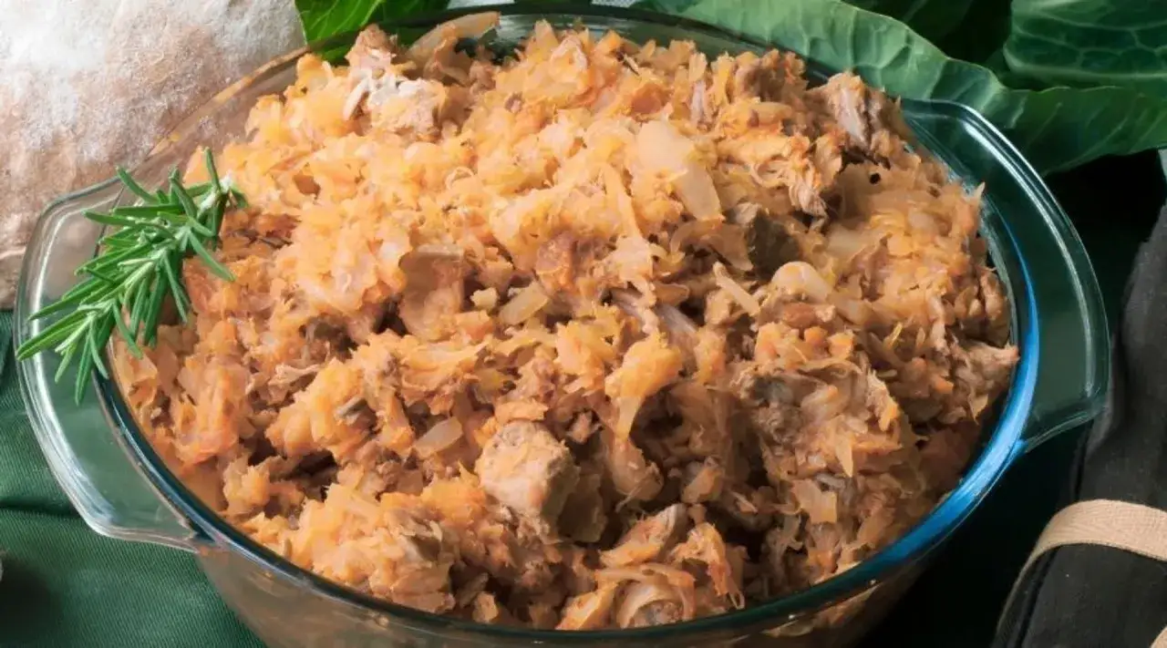 Gotowe danie z kapusty i mięsa w szklanej misie, ozdobione rozmarynem. Czy kapustę można mrozić? Tak, ta potrawa świetnie nadaje się do mrożenia.