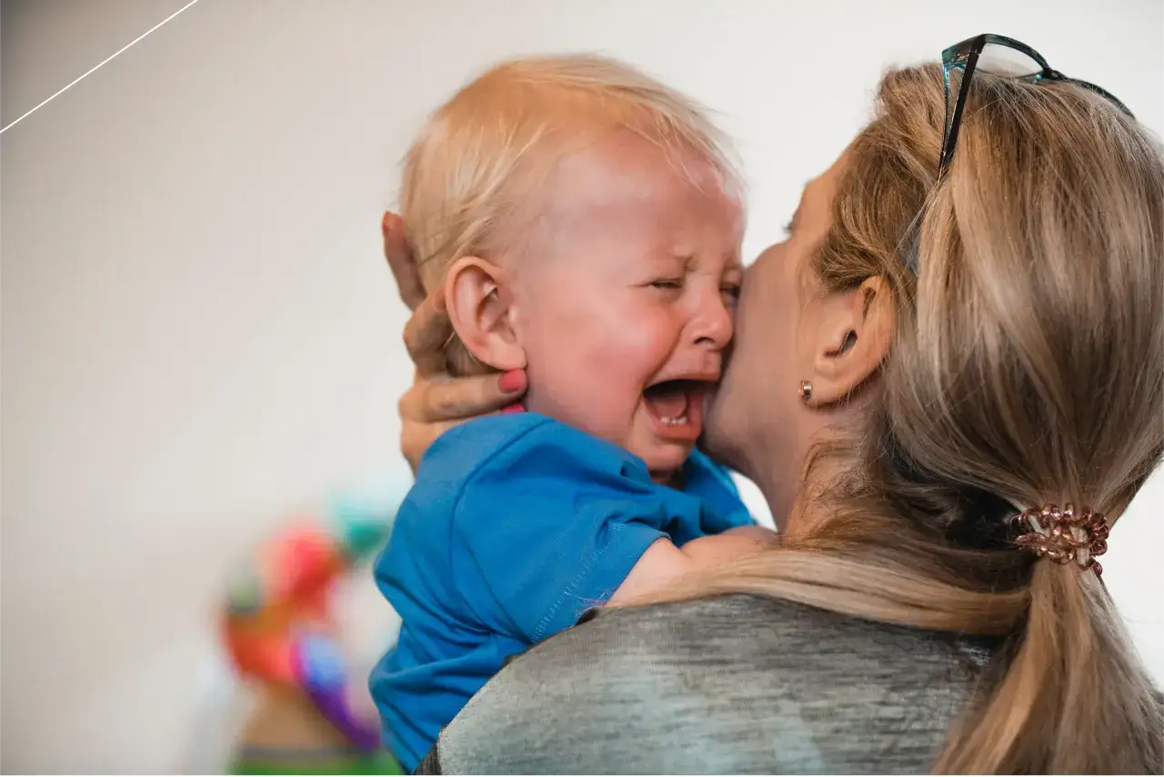 Rodzic przytulający płaczące dziecko