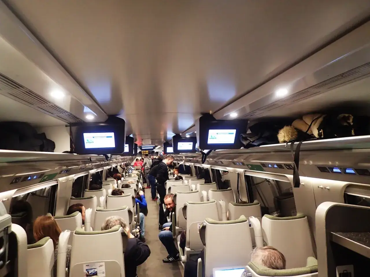 Wnętrze Pendolino, pasażerowie siedzą, podróż do Krakowa.