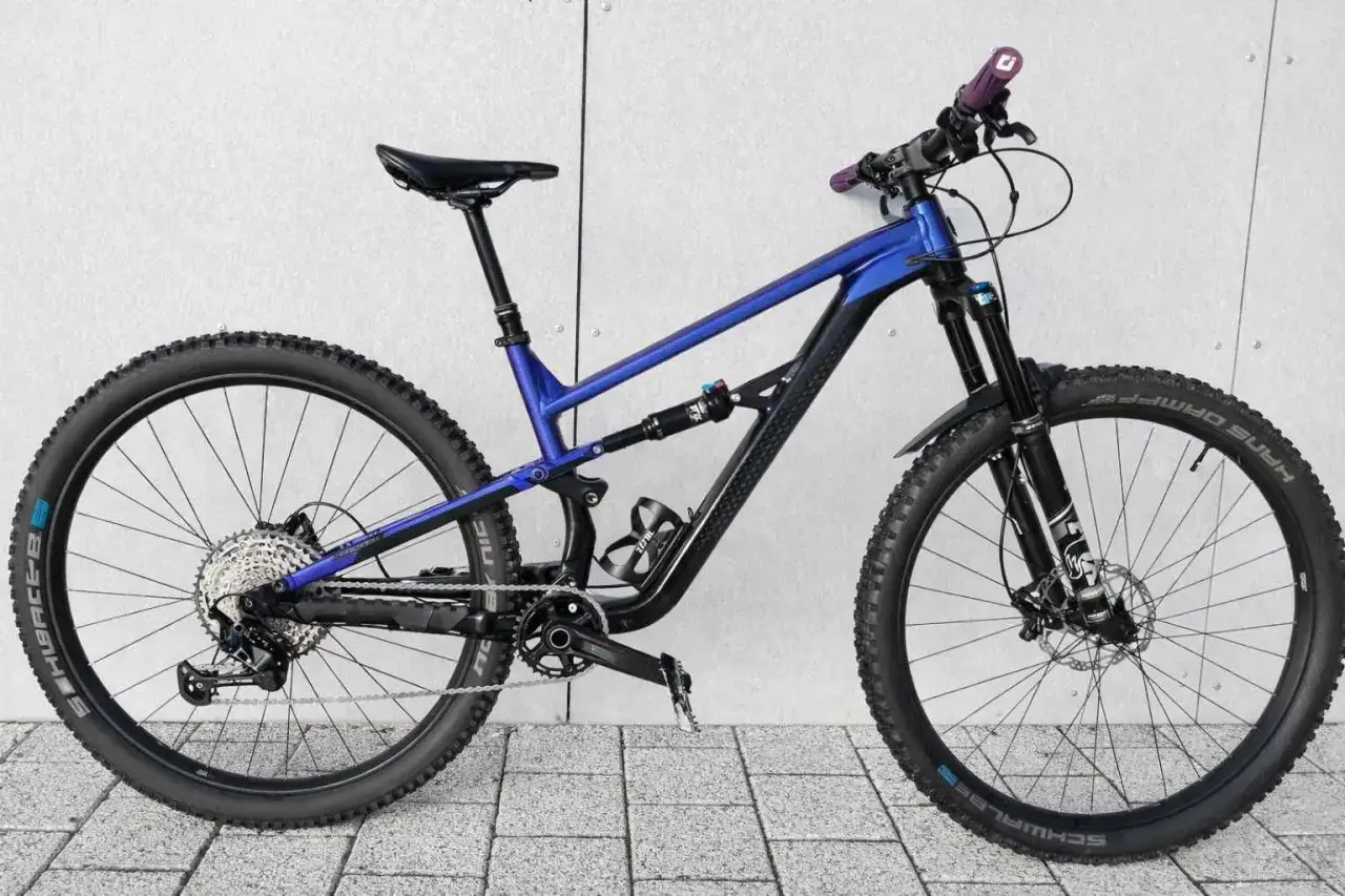 Niebiesko-czarny rower g&oacute;rski Polygon Siskiu T8 z pełnym zawieszeniem, gotowy na terenowe wyzwania.