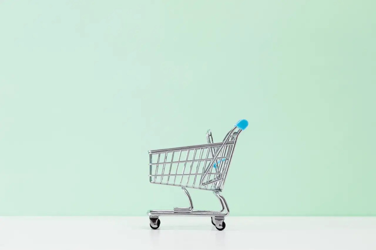 Miniaturowy wózek sklepowy na jasnym tle. Symbolizuje sytuacje, kiedy sprzedawca może odstąpić od umowy.