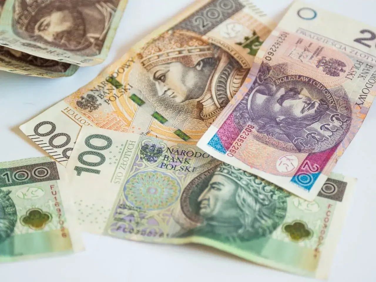 Złotówki na białym tle. Zastanawiasz się, ile pozyczek mozna miec w Wonga?