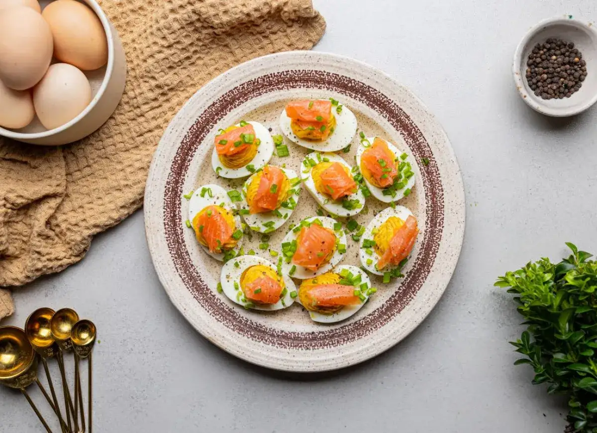 Pyszne jajka faszerowane z łososiem, posypane szczypiorkiem. Idealna przekąska na każdą okazję.