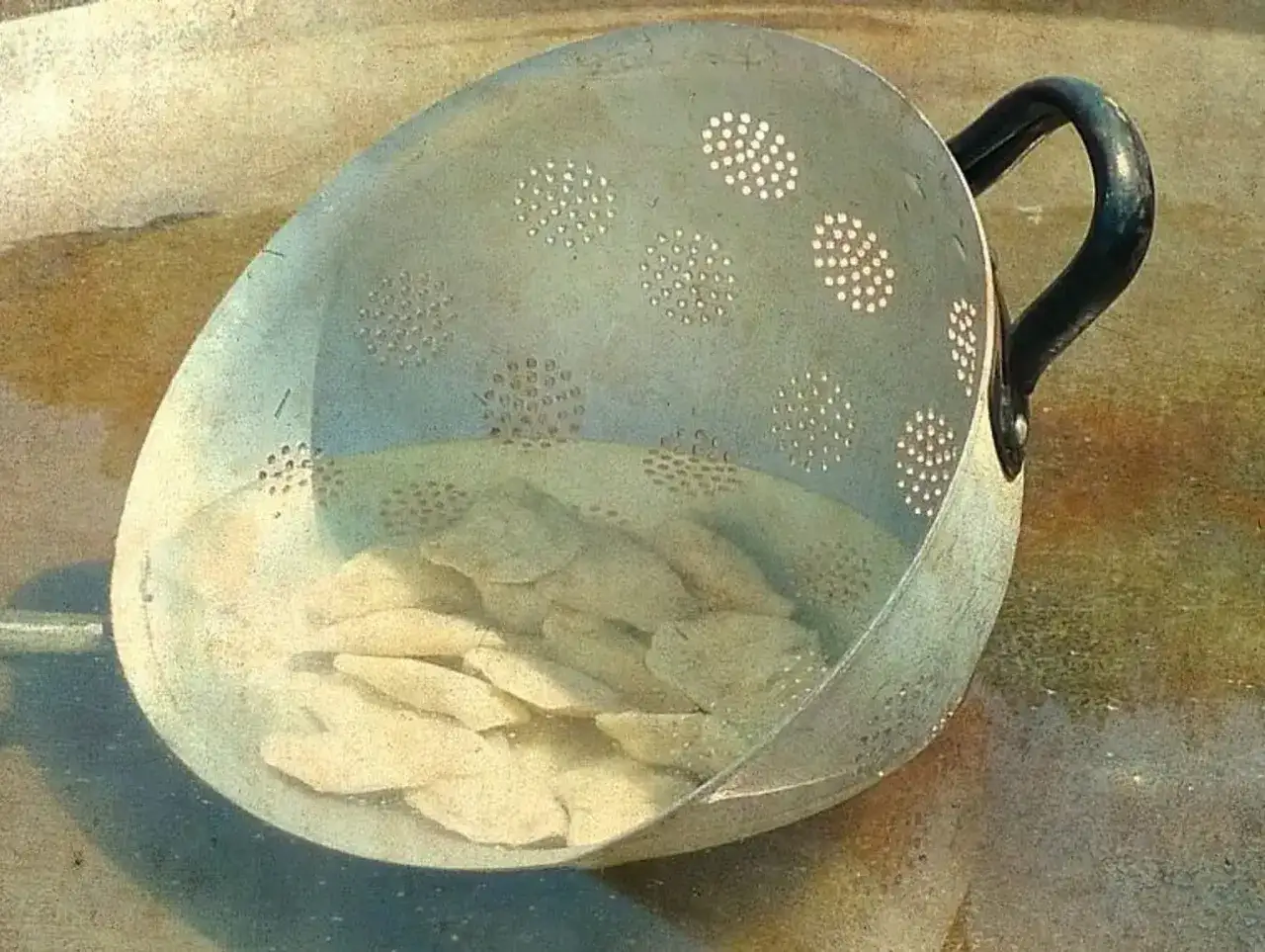garnek z wrzącą wodą i pierogami