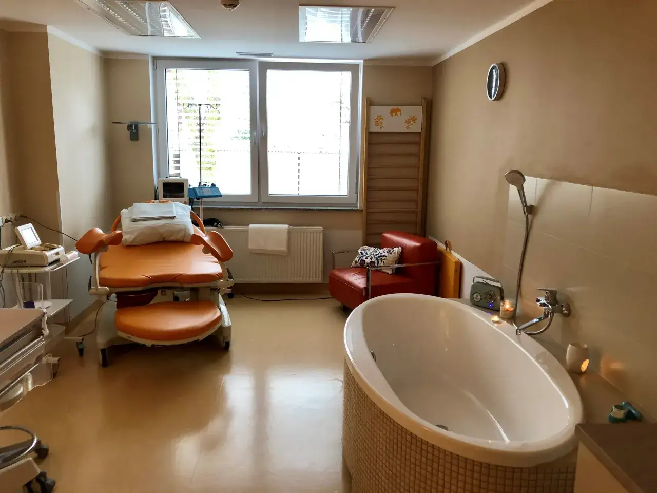 Pok&oacute;j porodowy z wanną i fotelem. Woda w wannie może pom&oacute;c, jak złagodzić skurcze porodowe.