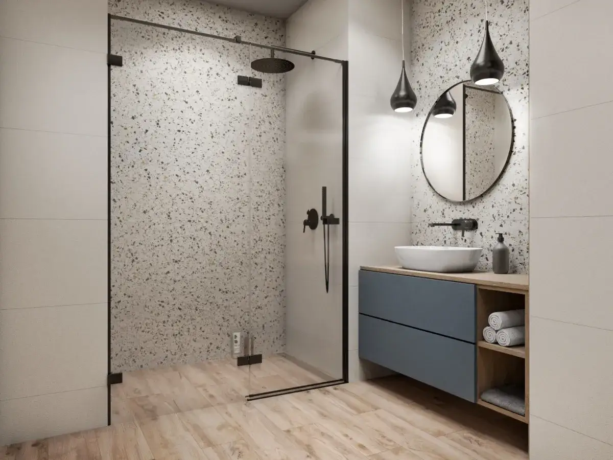 Nowoczesna, mała łazienka z prysznicem. Wnętrze zdobią płytki imitujące terrazzo i drewniane panele.