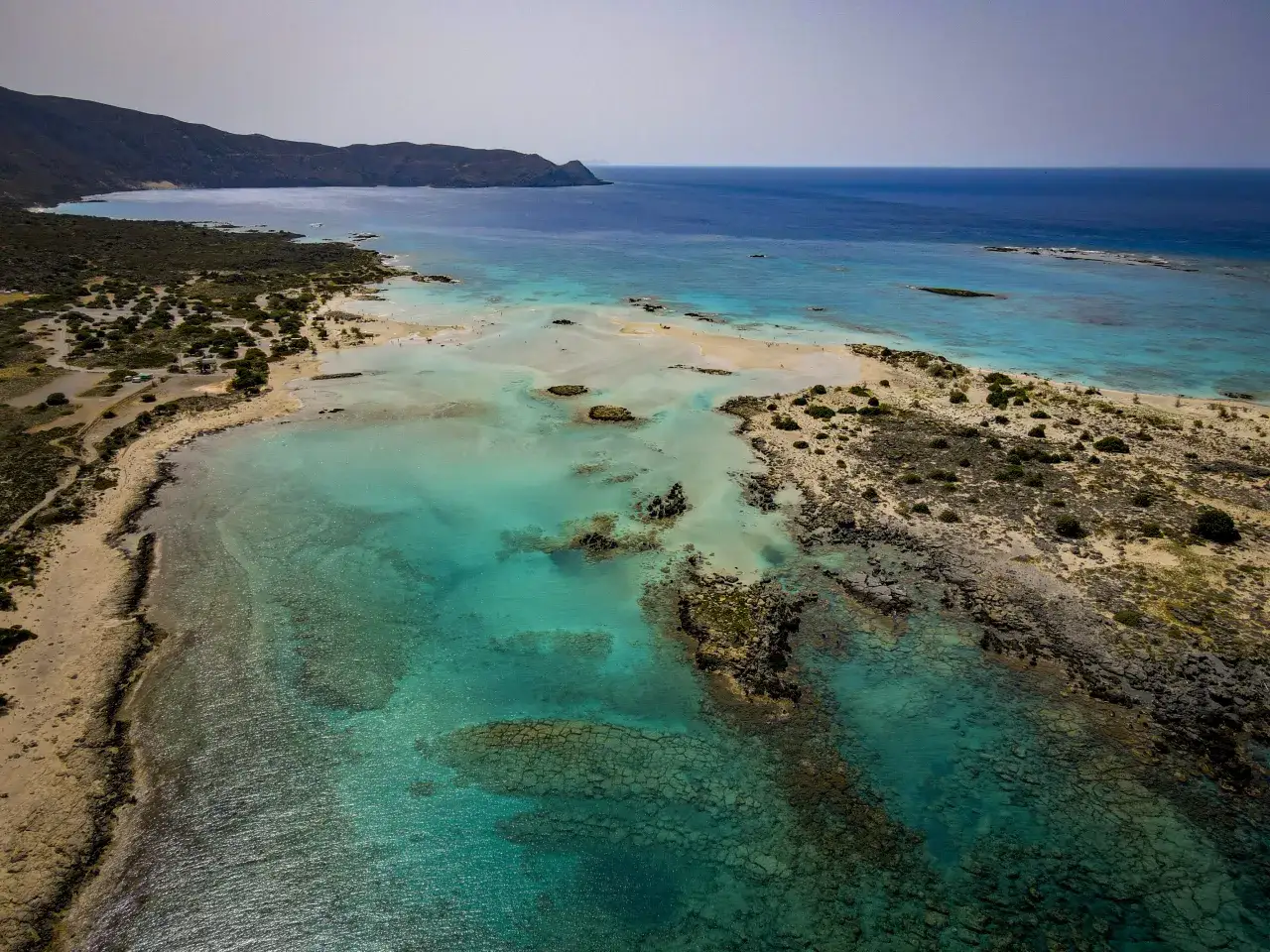 Malownicze plaże na Krecie z turkusową wodą i skalistym wybrzeżem.