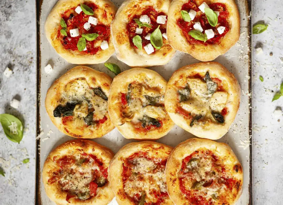 Mini pizze z ciasta do pizzy, w tym margherita z bazylią i mozzarellą, oraz z dodatkiem karczochów i szpinaku. Idealne przekąski!