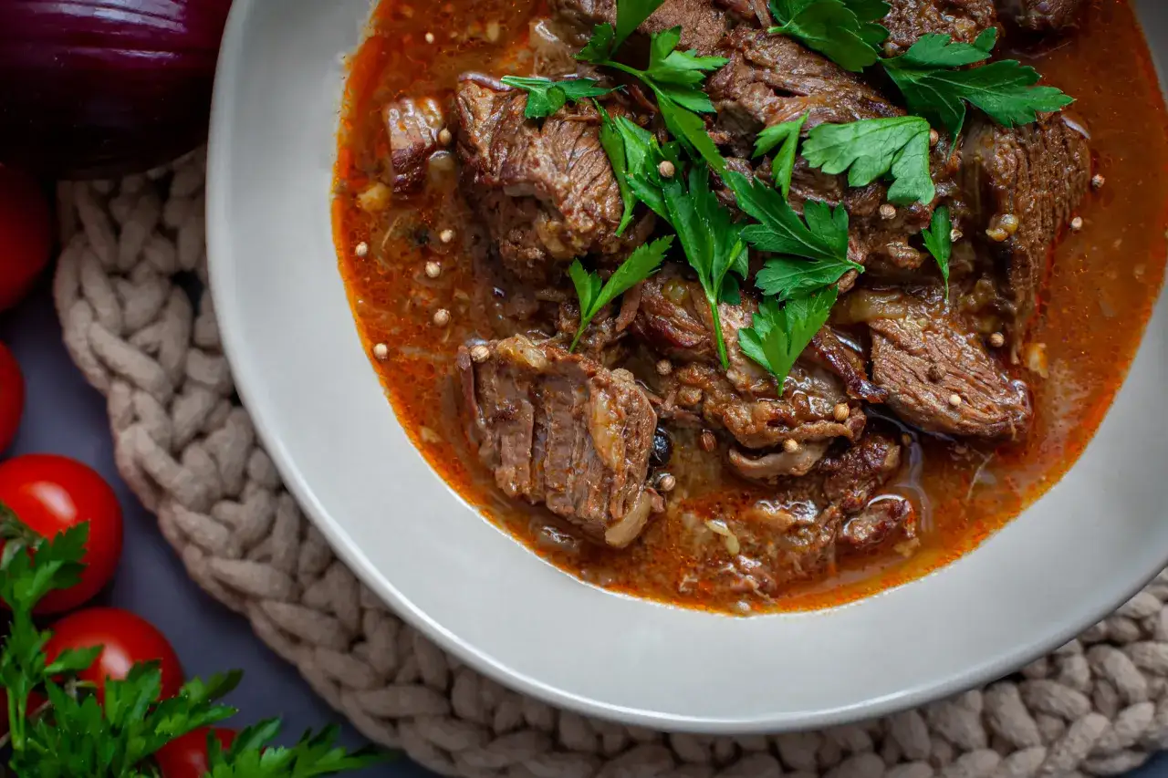Gulasz wołowy z dodatkiem ziół, idealny do rozplywania się w ustach. Kluczem jest odpowiedni czas duszenia wołowiny na gulasz.