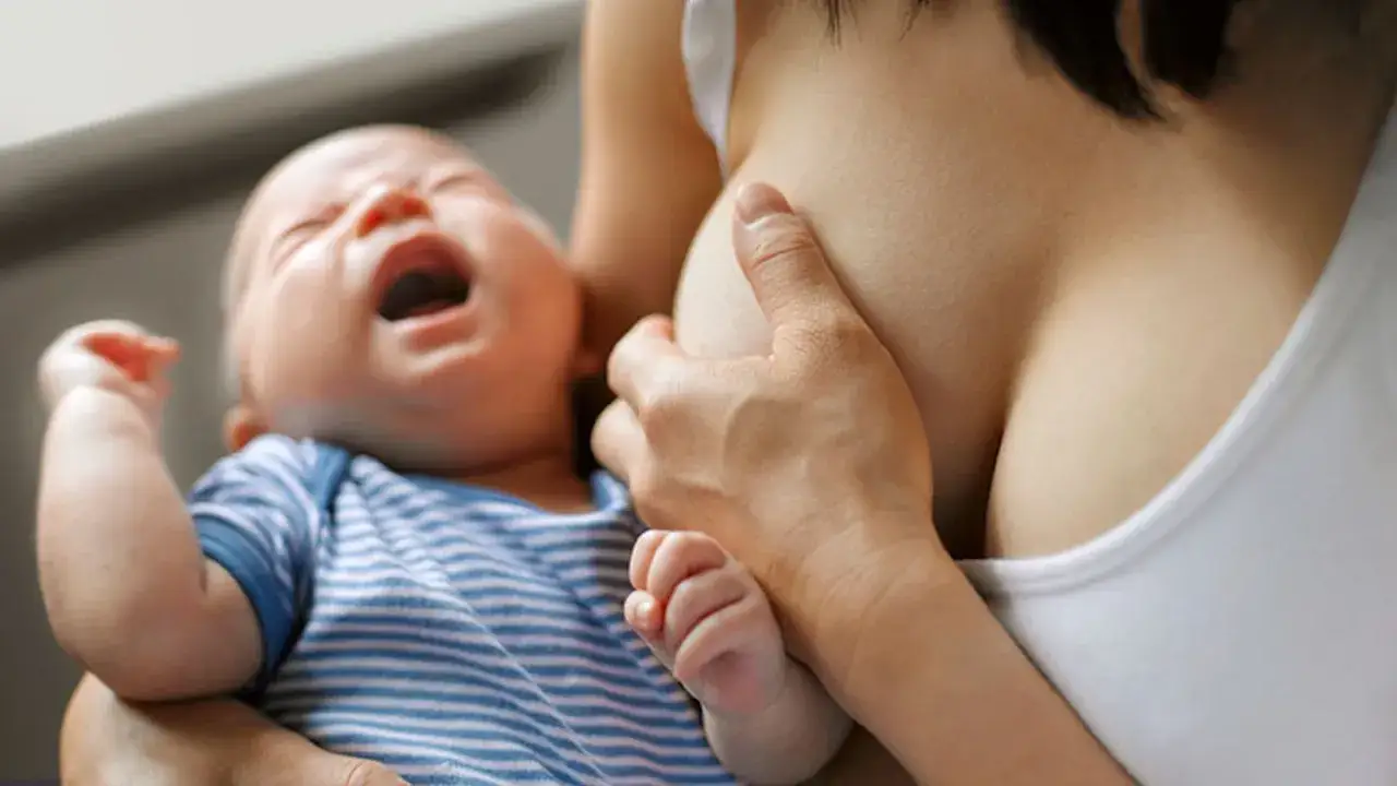 Płaczący niemowlak karmiony piersią. Matka zastanawia się, czy ibuprofen przy karmieniu piersią jest bezpieczny.