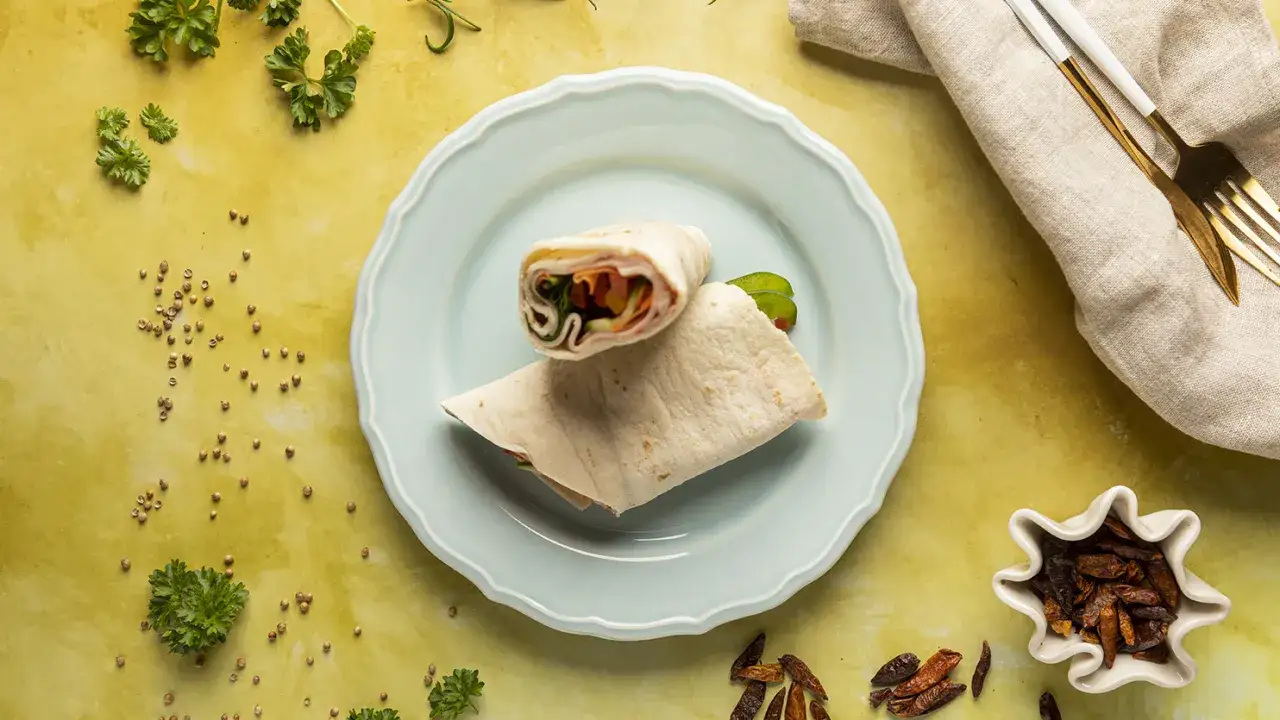 Tortilla z szynką i warzywami na talerzu. Czy można jeść tortille na diecie? Tak, jeśli wybierzesz zdrowe składniki!