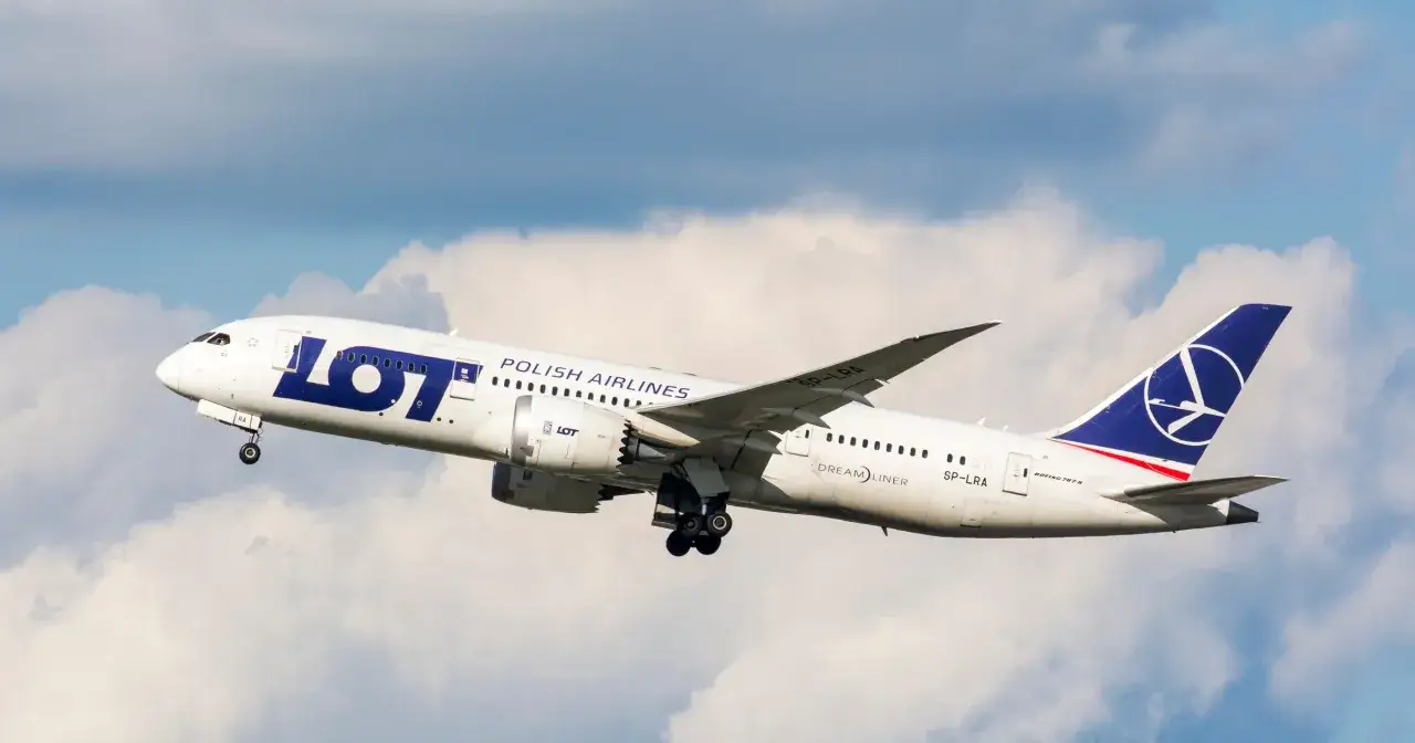 Samolot LOT Polish Airlines wznosi się na tle chmur. Zastanawiasz się, ile trwa lot z Warszawy do Tokio?