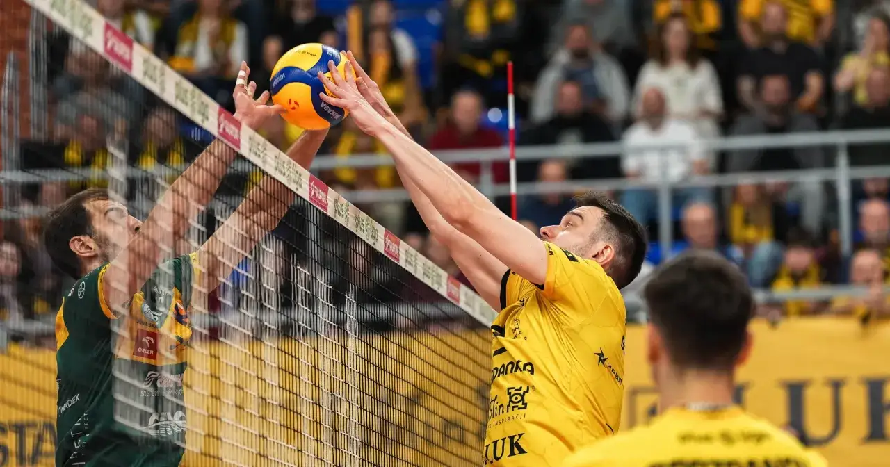 Siatkarze walczą o piłkę przy siatce. Napięcie w meczu **liga mistrzów siatkówka** jest wyczuwalne.