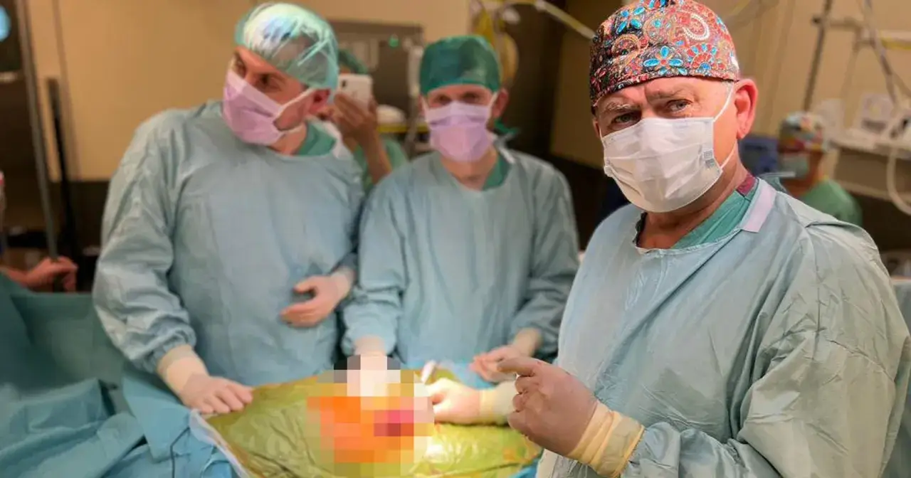 Chirurdzy w maseczkach i czepkach pracują nad pacjentem z zaawansowaną schyłkową niewydolnością nerek.