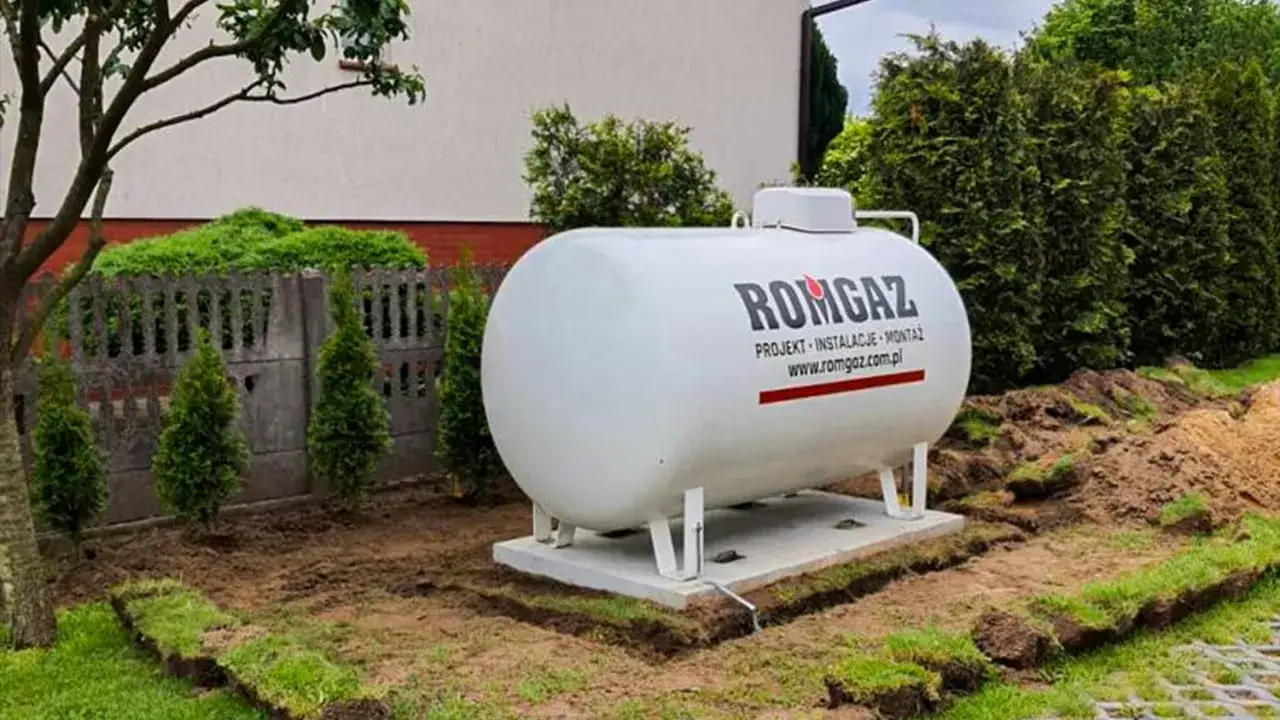 Zbiornik na gaz 2700 na ile wystarcza? Duży, biały zbiornik na gaz ziemny, zamontowany w ogrodzie, gotowy do ogrzewania domu.