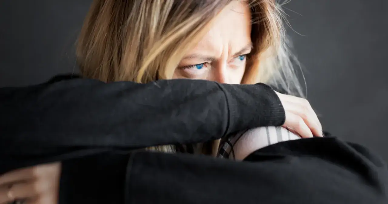 osoba zmęczona, trzymająca się za głowę, symbolizująca fizyczne objawy stresu