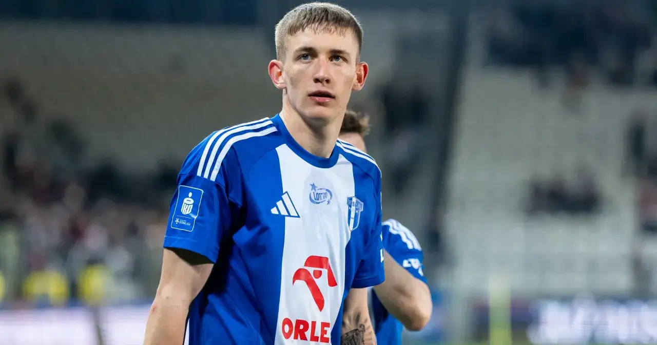 Piłkarz w niebiesko-białej koszulce z logo Ekstraklasy. Chcesz wiedzieć, gdzie można obejrzeć mecze ekstraklasy na żywo?