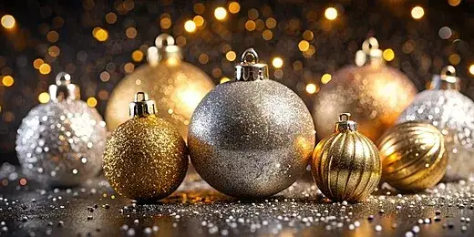 eleganckie, minimalistyczne zdjęcie przedstawiające złote i srebrne ozdoby świąteczne na ciemnym tle