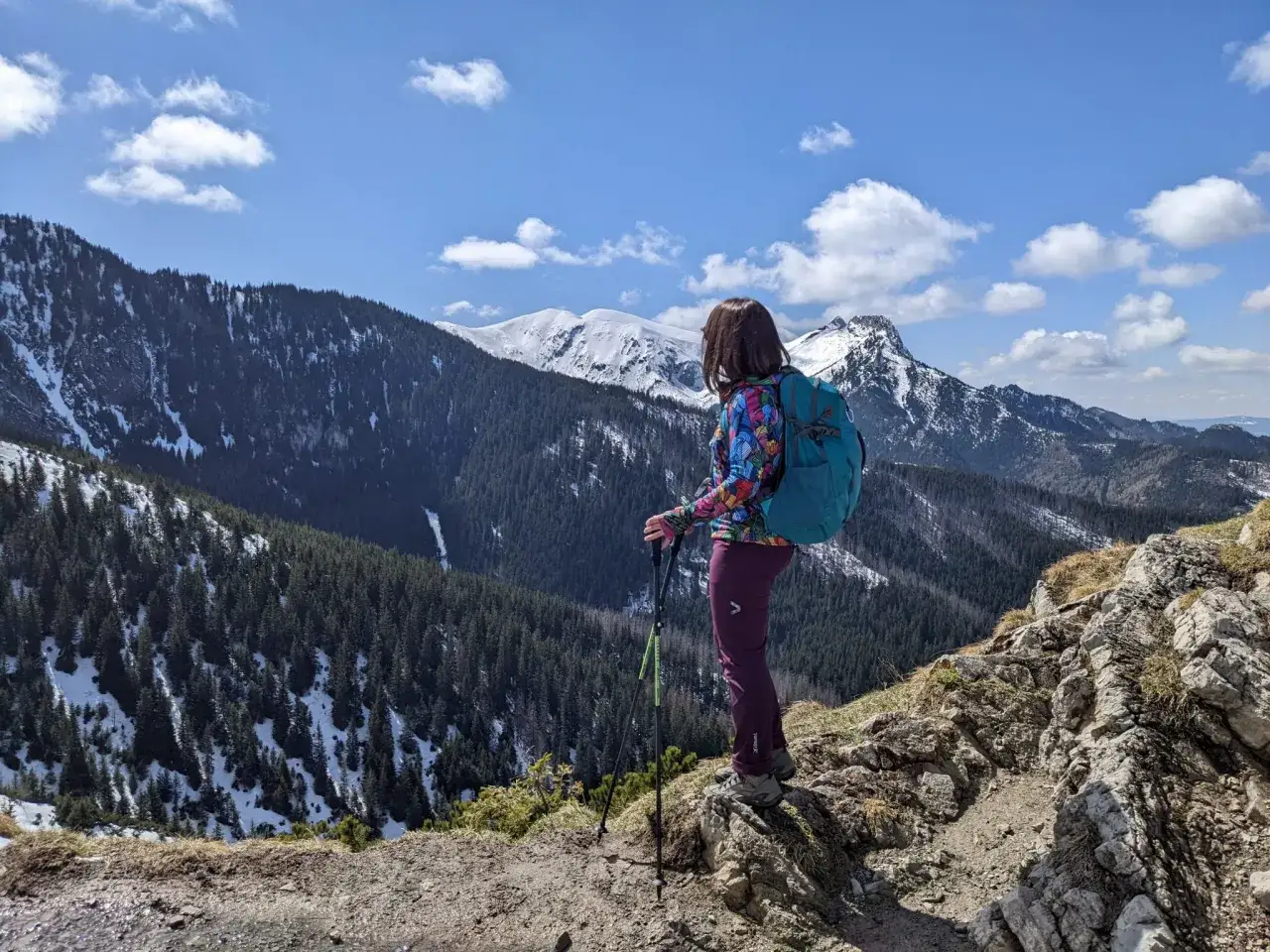Widok na ośnieżony Kościelec dla kogoś, kto kocha g&oacute;ry. Turystka z plecakiem podziwia panoramę Tatr.