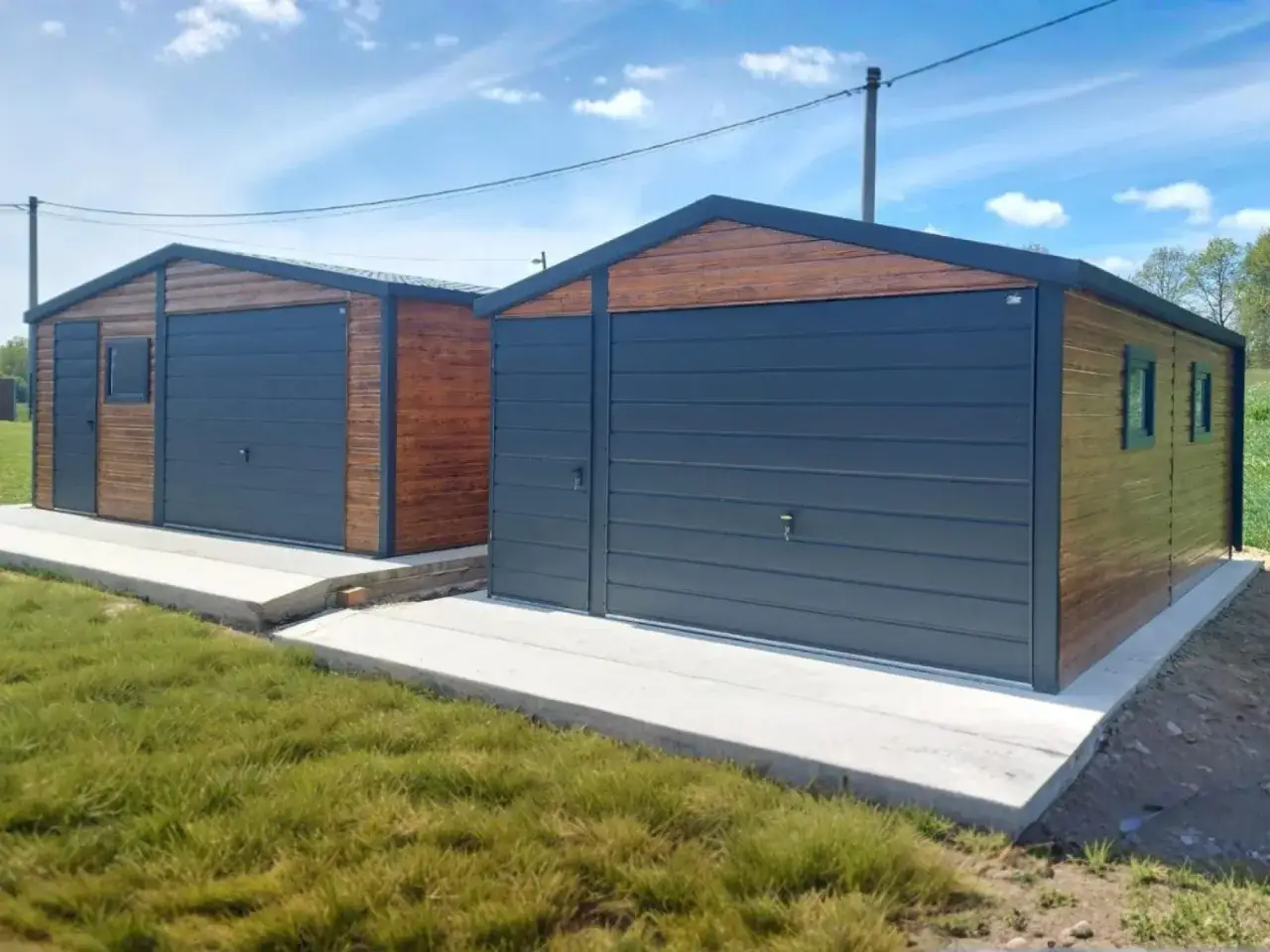 Dwa nowoczesne garaże blaszane konstrukcja, z drewnianymi elementami i ciemnoszarymi bramami, stoją na betonowych podstawach.