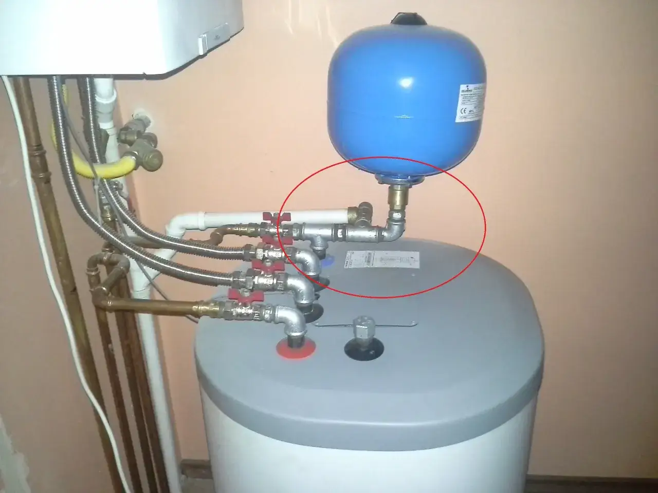 Zawór upustowy w piecu gazowym znajduje się przy niebieskim naczyniu przeponowym, połączonym z instalacją.