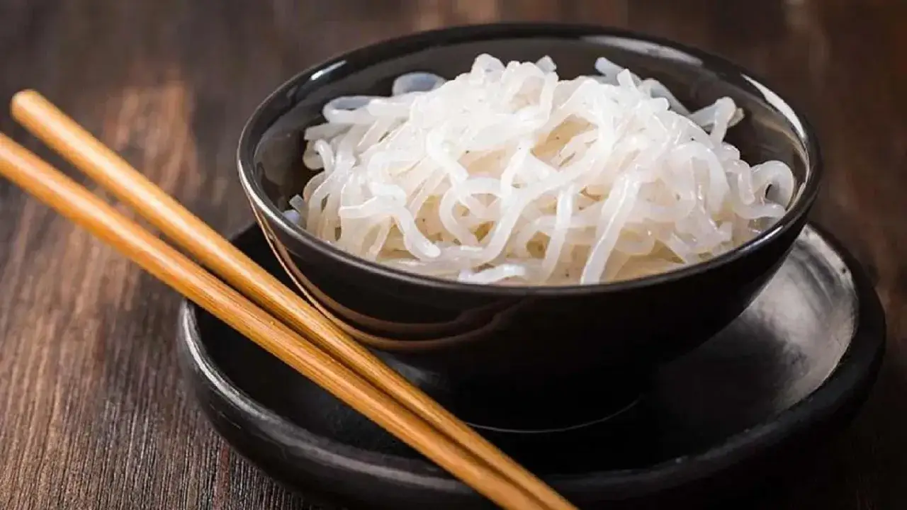 Miseczka z makaronem konjac, gotowym do spożycia. Pałeczki leżą obok, czekając na posiłek.