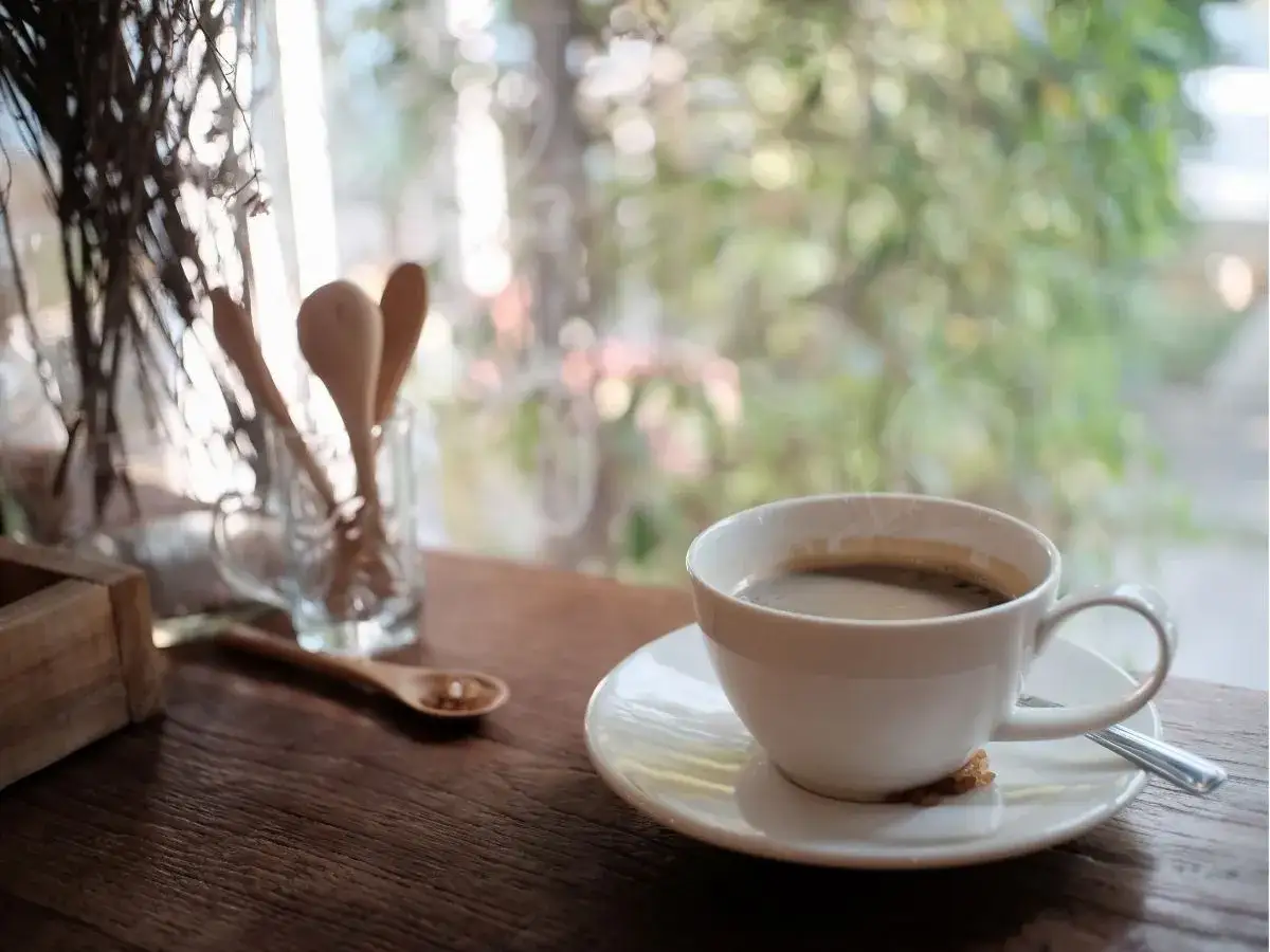 Gorąca kawa Inka paruje w filiżance na drewnianym stole. Czy kawa Inka jest zdrowa? To pytanie zadaje sobie wiele os&oacute;b.