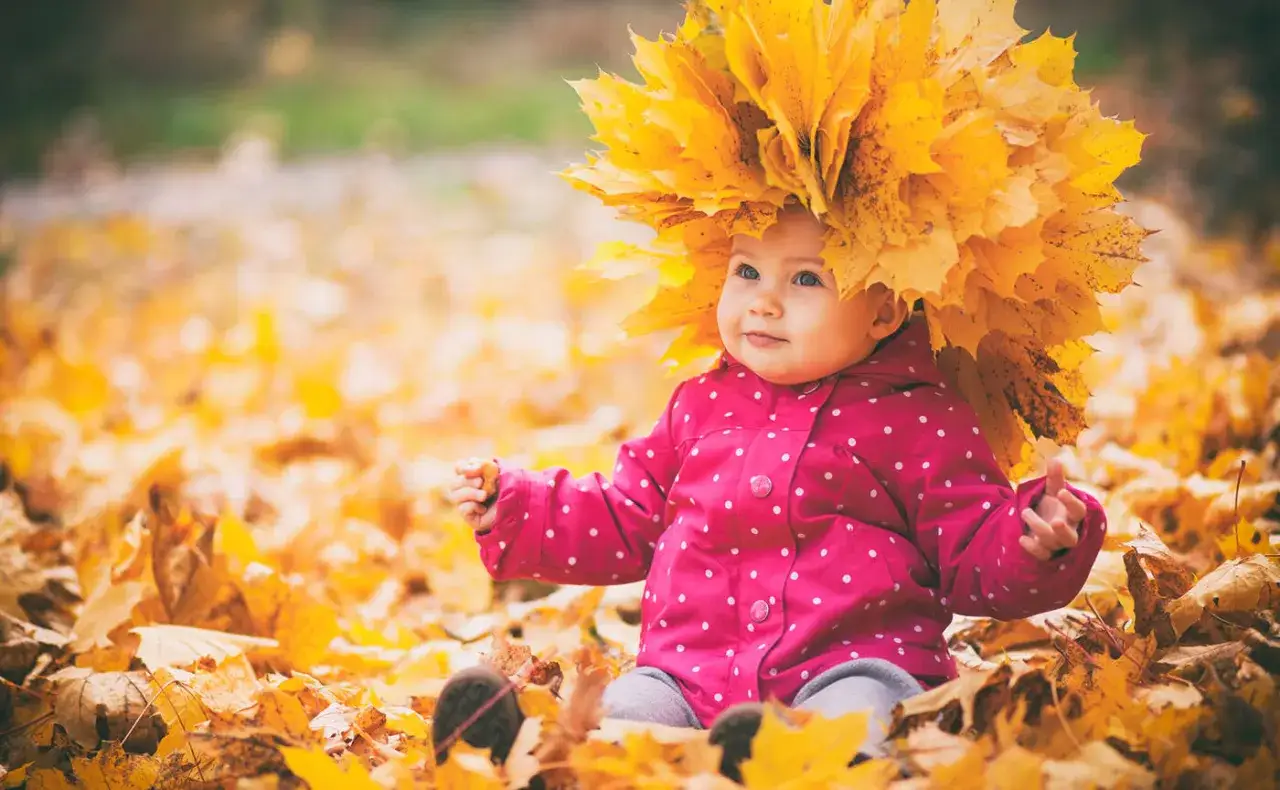 Dzieci bawiące się w jesiennych liściach