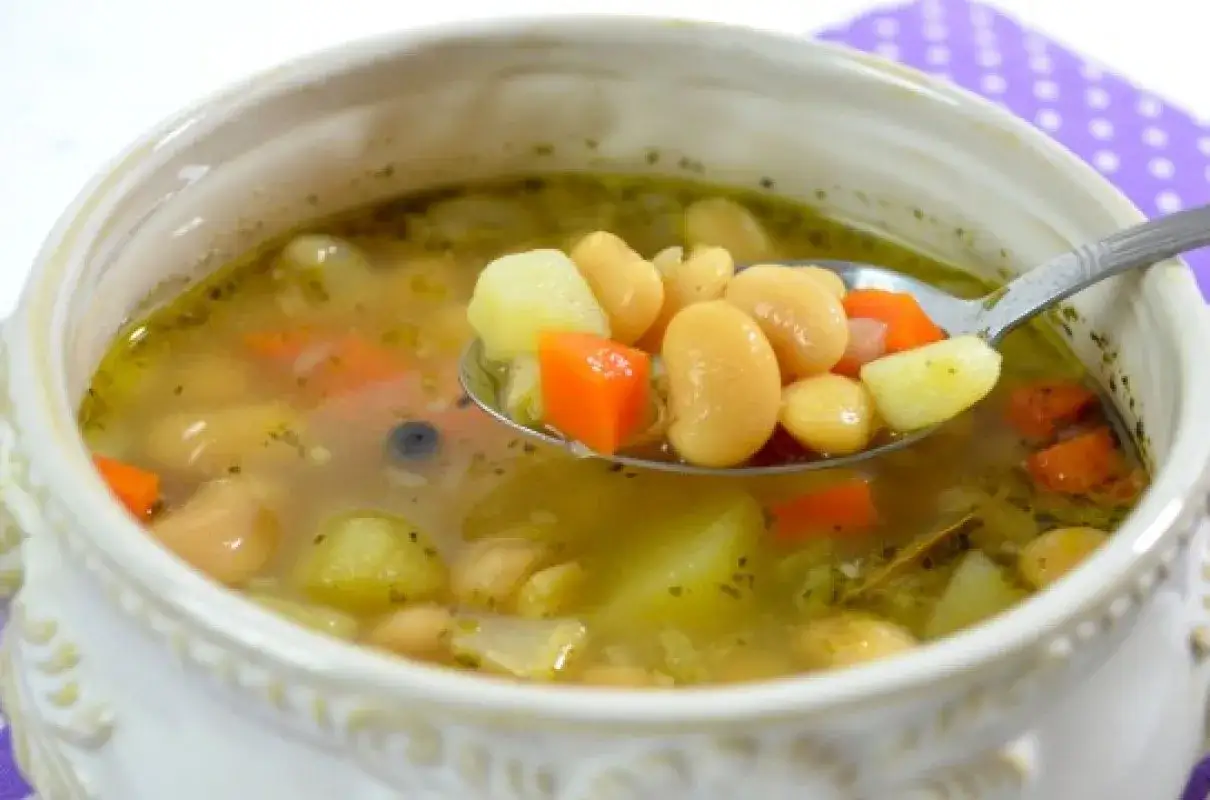 Talerz sycącej zupy fasolowej z ziemniakami i marchewką. Zastanawiasz się, ile kalorii ma talerz zupy fasolowej?