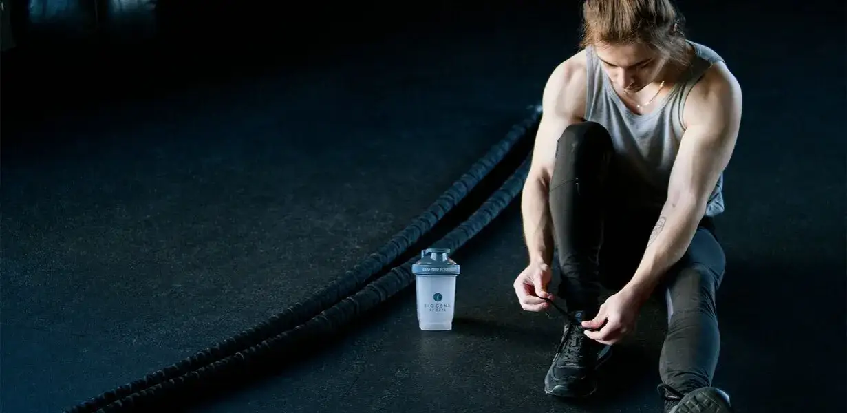 Osoba pijąca shake proteinowy przed treningiem