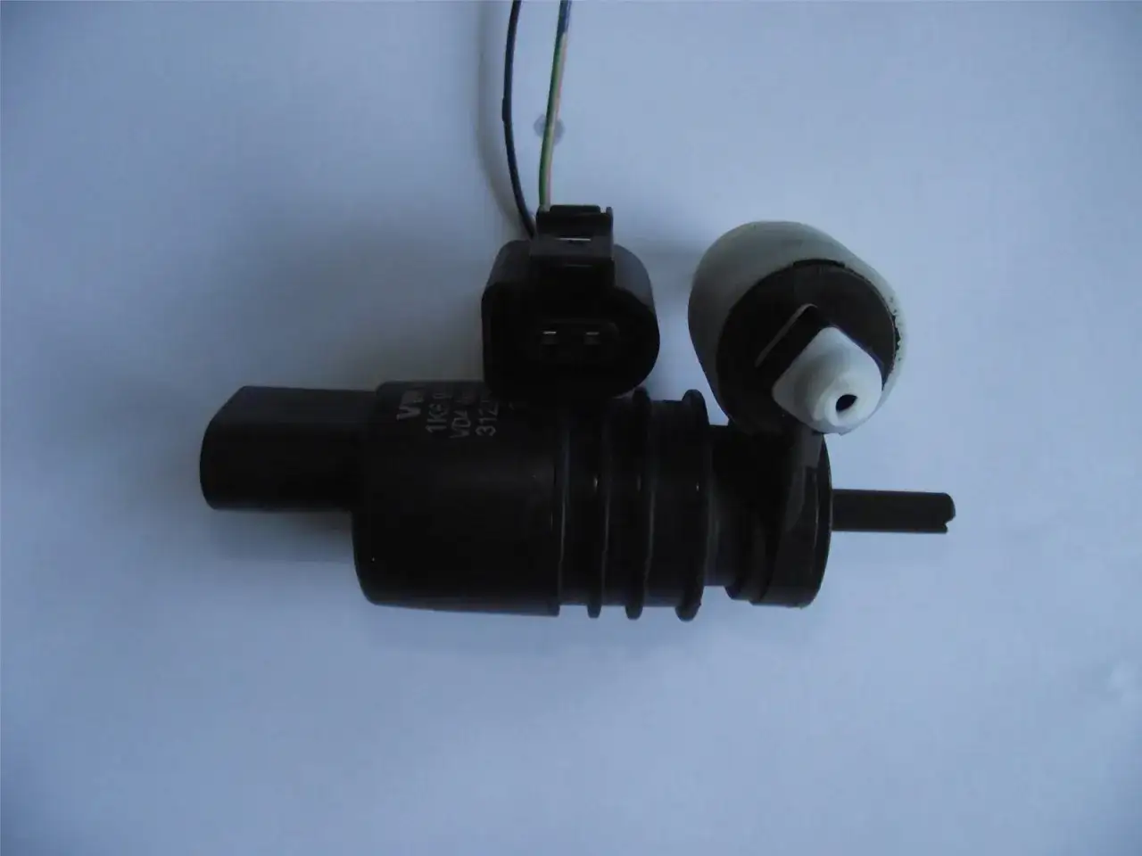 Pompa spryskiwaczy VW, gdy nie działają spryskiwacze, może wymagać wymiany. Widoczny element z przewodami i złączem.