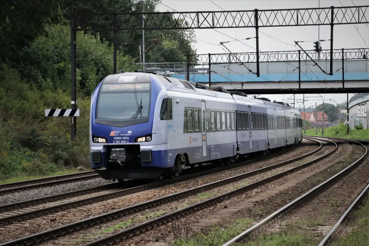 Nowoczesny pociąg PKP Intercity ED160-003a, relacji Olsztyn-Warszawa, pokonuje zakręt na torach.
