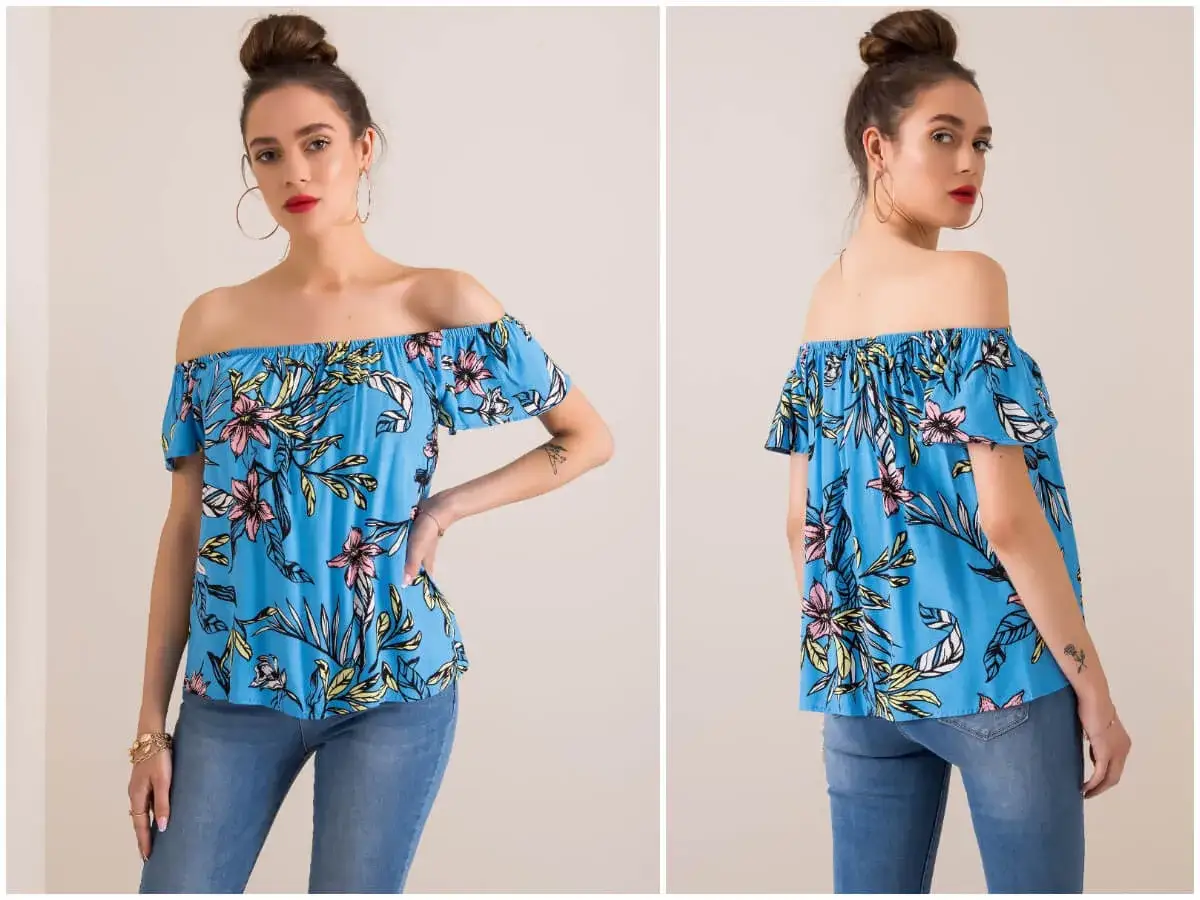 Modelka w kwiecistej bluzce hiszpance z odkrytymi ramionami, prezentująca letnią stylizację.