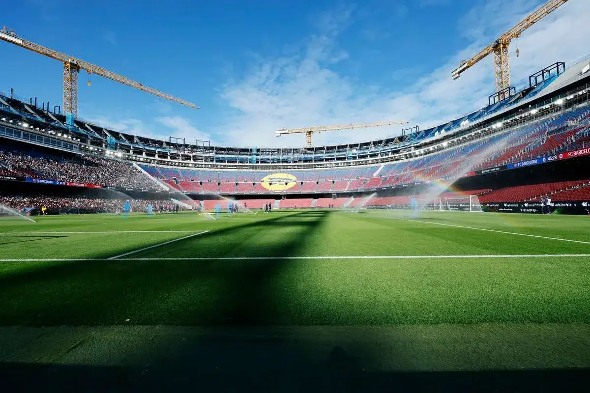 Stadion Camp Nou w budowie, z dźwigami i zraszaczami na murawie. Czy Barcelona gra w Lidze Mistrzów?