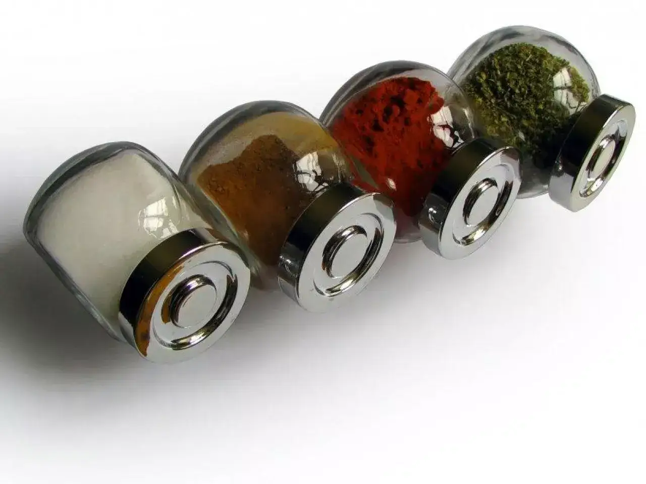 Cztery słoiczki z przyprawami: sól, kurkuma, papryka i zioła. Polski producent przypraw dba o jakość.