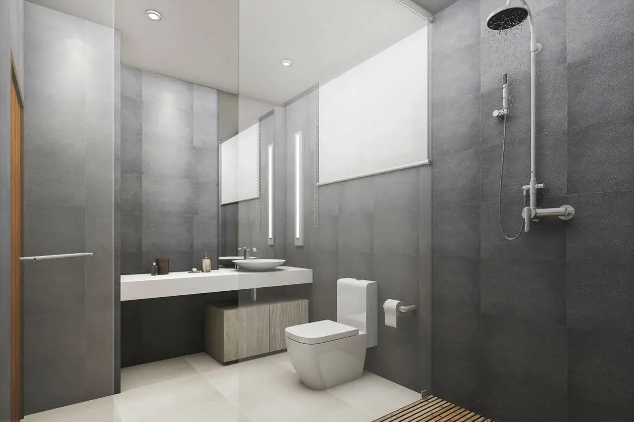 Nowoczesna łazienka z szarymi płytkami, prysznicem i umywalką. Woda spływa po ścianie, co sugeruje, że fuga jest wodoodporna.