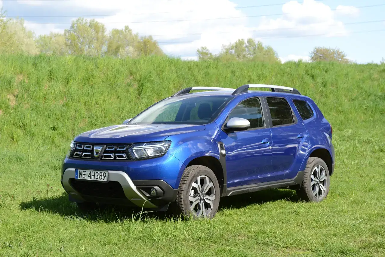 Niebieski Dacia Duster na tle zielonej łąki. Zastanawiasz się nad jego spalaniem?