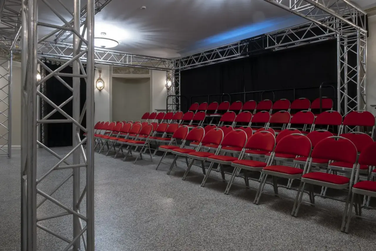 Puste czerwone krzesła czekają na widzów. Zastanawiasz się, ile przed spektaklem być w teatrze?
