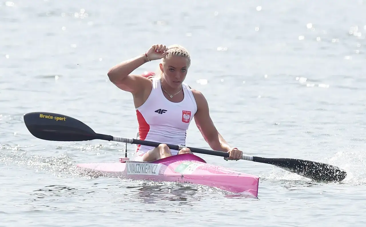 Polka w kajaku walczy o medal na igrzyskach olimpijskich. Woda rozpryskuje się wokół wiosła.