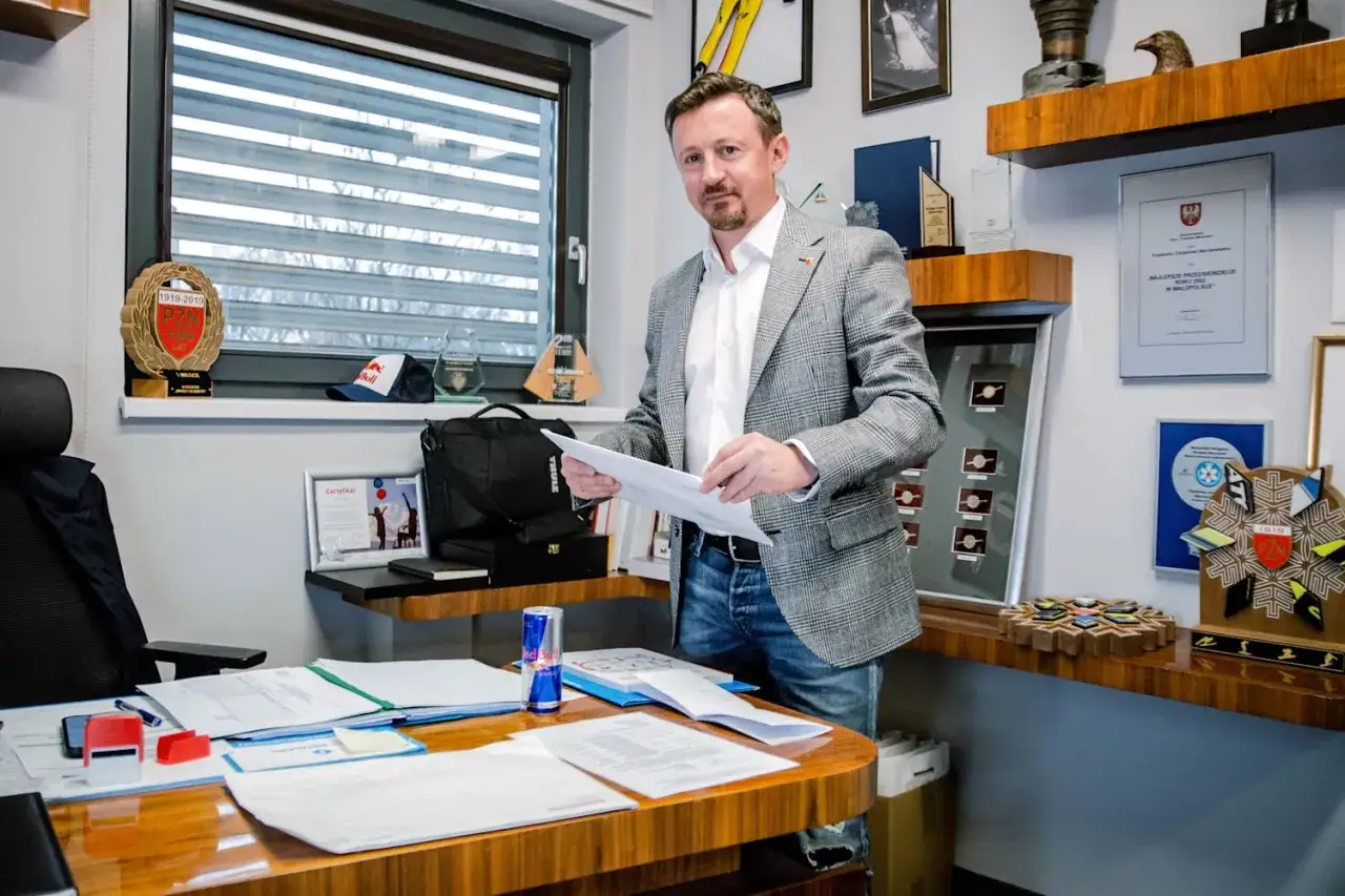 Adam Małysz w swoim gabinecie, otoczony pucharami i pamiątkami, świadczy o jego imponującym majątku i sukcesach.