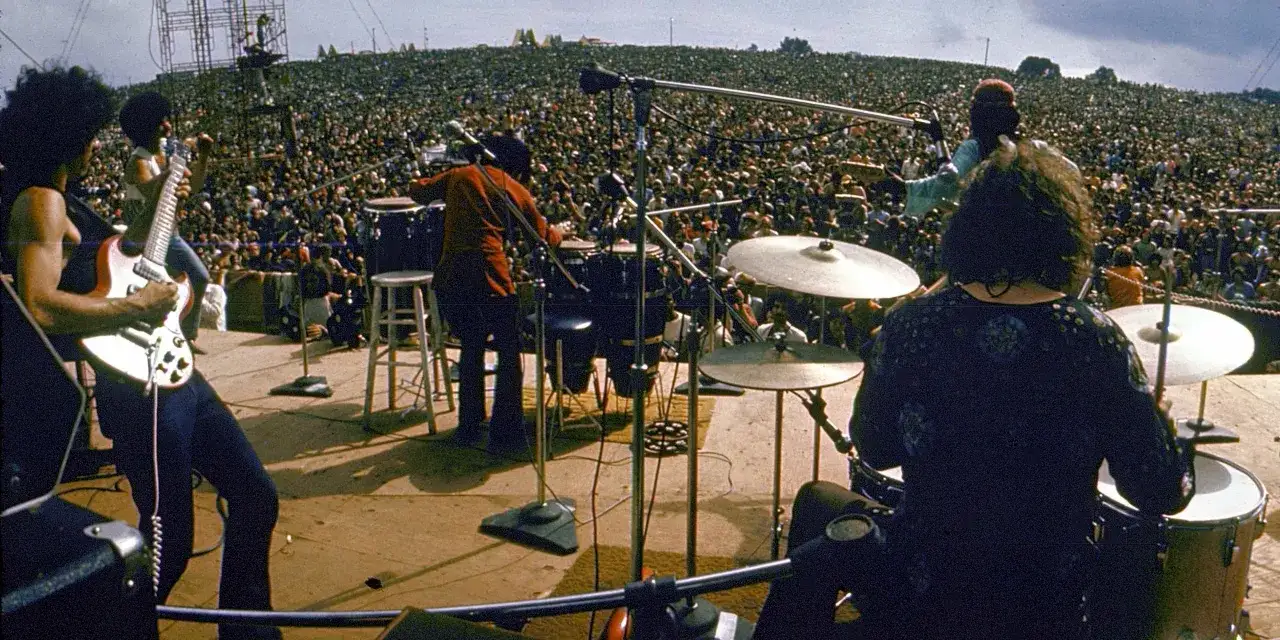 Koncert na Woodstocku, gdzie tłumy ludzi słuchają muzyki na żywo. To właśnie woodstock co to za wydarzenie!